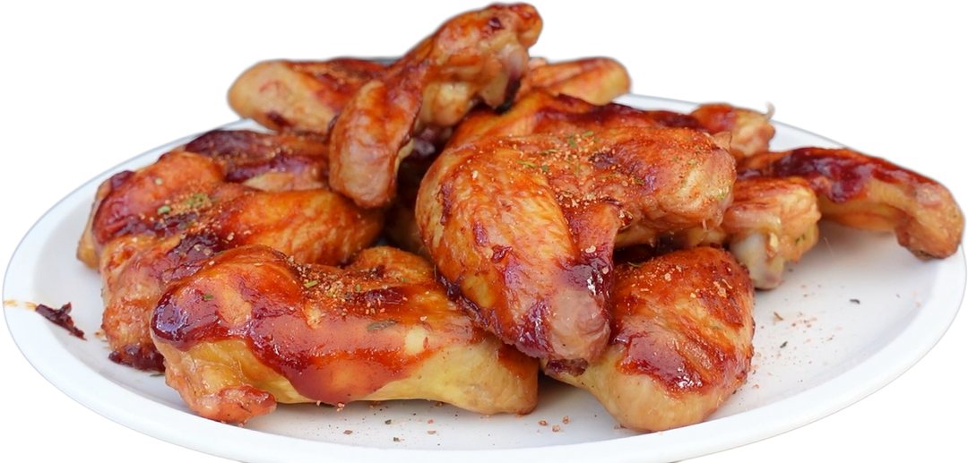 Saftige, glasierte Chicken Wings mit Kikeriki Gewürzmischung auf einem Teller