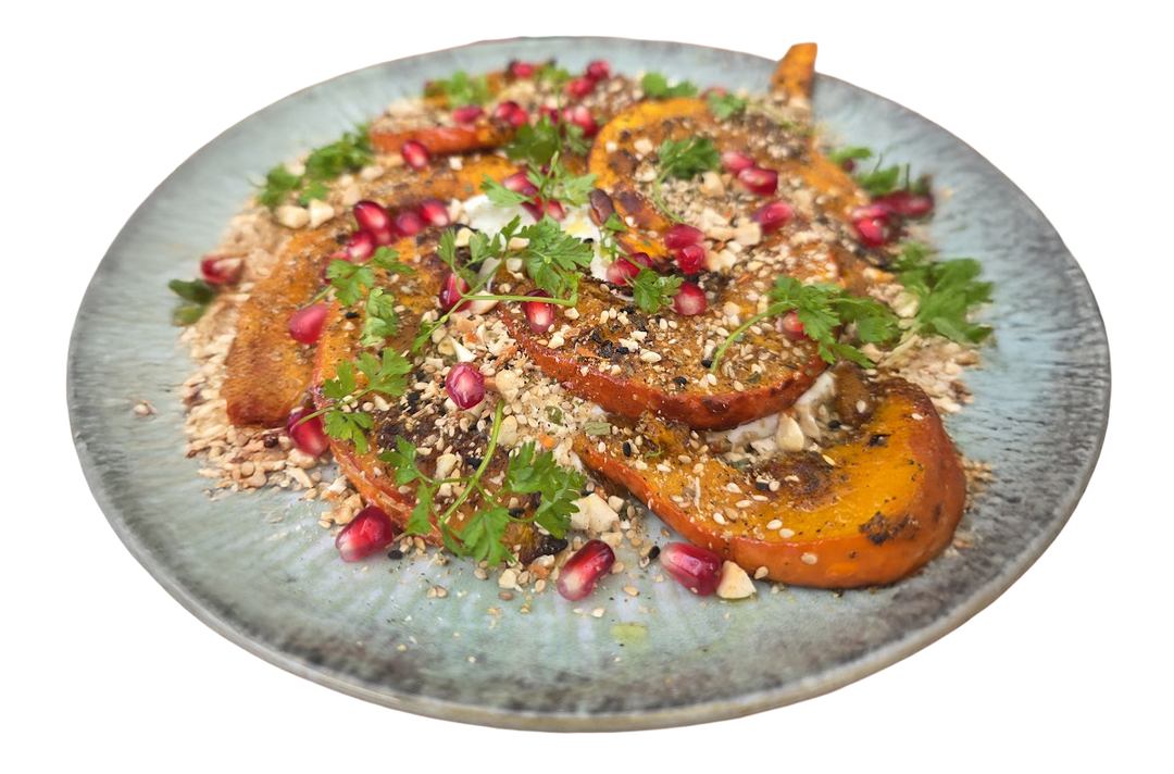 eröstete Hokkaido-Kürbisspalten auf cremigem Joghurt, garniert mit selbstgemachter Nuss-Gewürzmischung (Dukkah), Granatapfelkernen und Koriander.